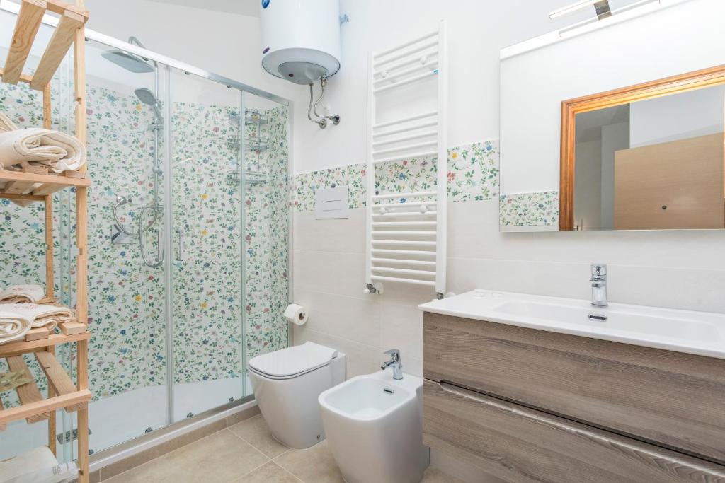 a bathroom with a toilet and a sink and a shower at Sentiti A Casa - Bronte in Bronte