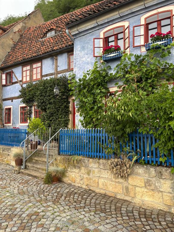 a blue house with red windows and a blue fence at Ferienwohnung Blaue Maus in Meißen