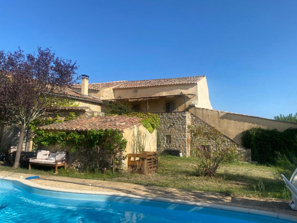 a house with a swimming pool in front of it at La Voûte Des Oliviers in Bessas