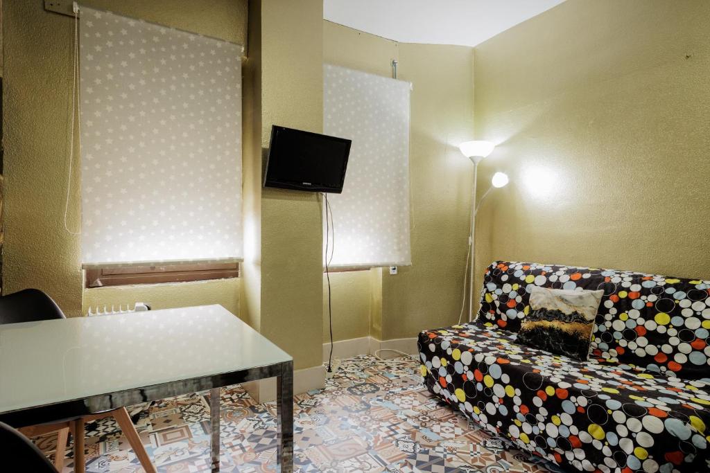 a living room with a couch and a tv at Triana Historic Center in Seville