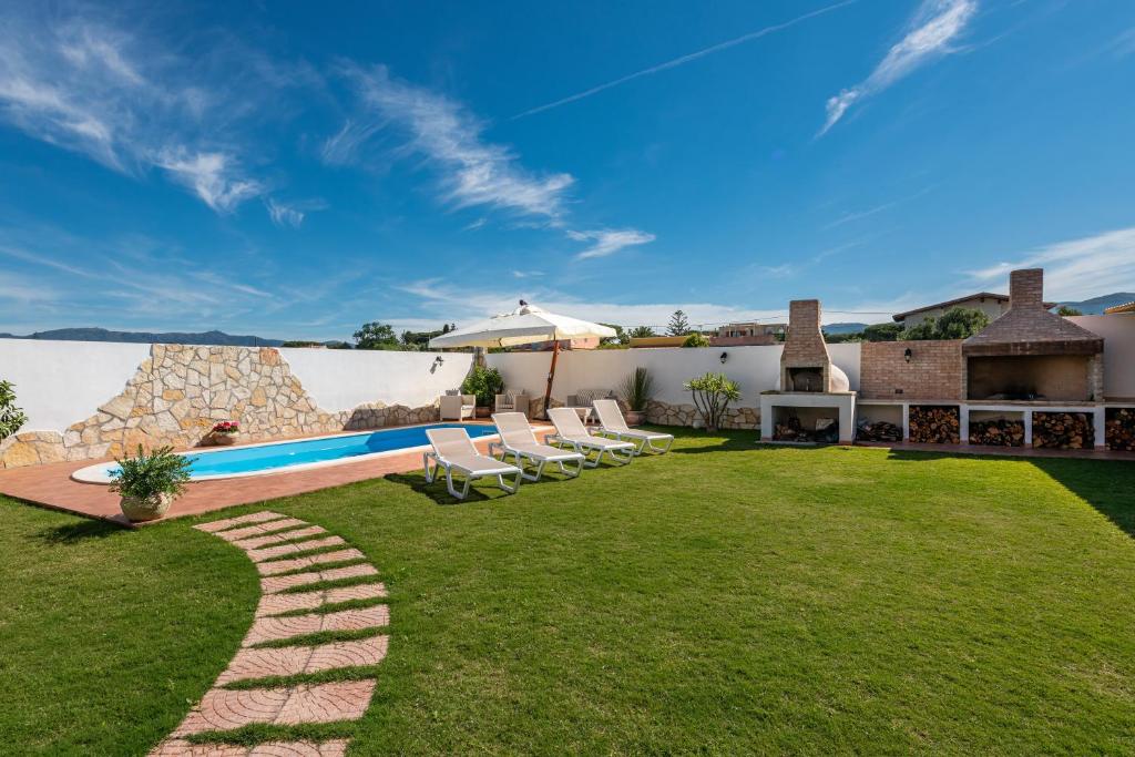 a yard with lounge chairs and a swimming pool at Villa Gle in Quartu SantʼElena