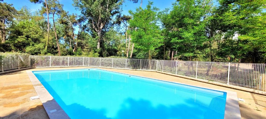 a swimming pool in a backyard with a fence at La maison de Fabien - Piscine in La Tranche-sur-Mer