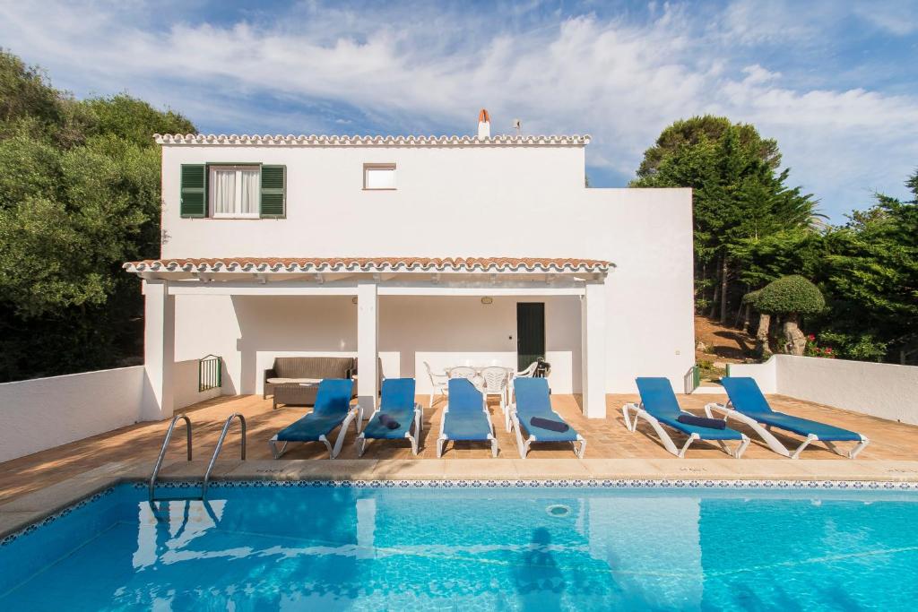 a villa with a swimming pool in front of a house at Villa Mariola in Sant Lluis