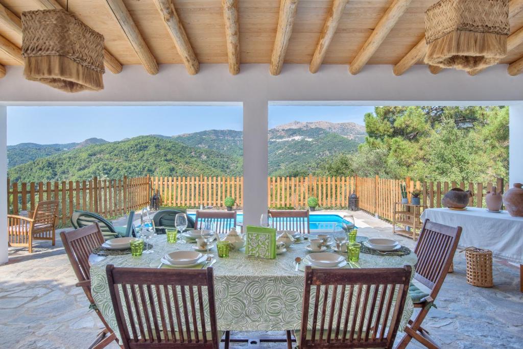 a table on a patio with a view of the mountains at Casa Rural Monte Dios in Jubrique
