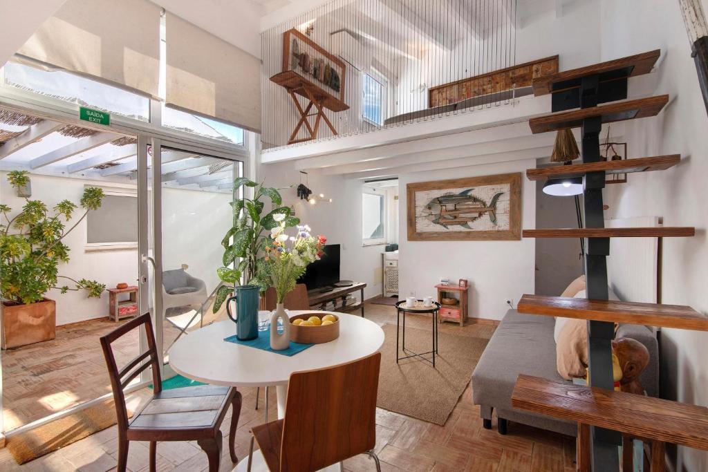 a room with a table and chairs and a loft at Estúdio Casa Do Limoeiro in Nora