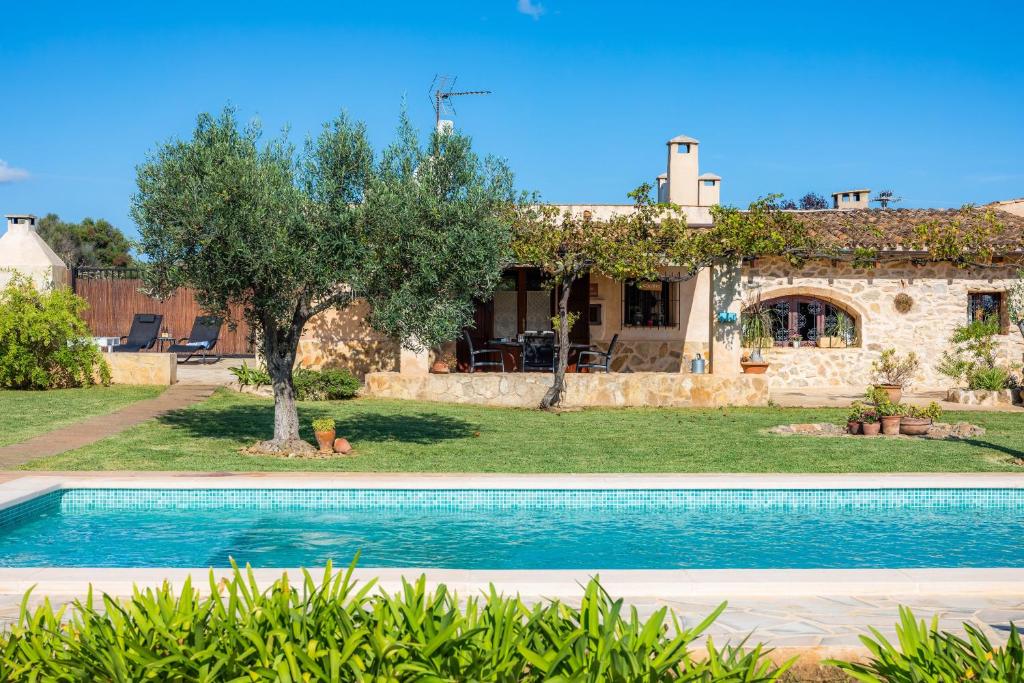 a villa with a swimming pool in front of a house at Ca Sa Padrineta in Capdepera