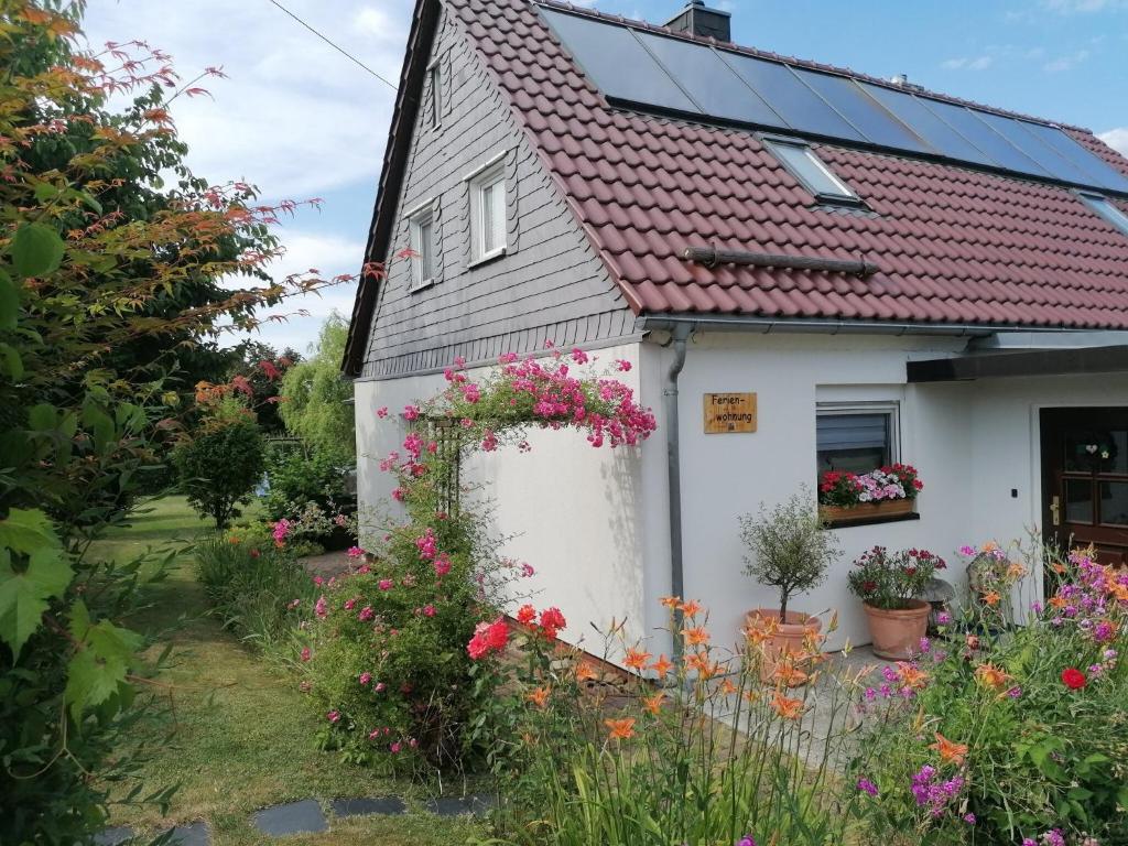 a small white house with flowers in the yard at Ferienwohnung Seilerberg in Freiberg