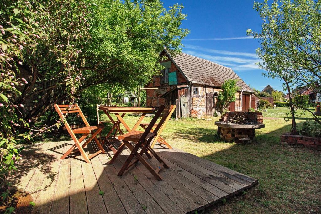 two wooden chairs and a table on a wooden deck at Ferienwohnung Alte Bauernkate in Süderholz