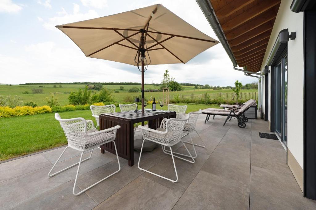 a patio with a table and chairs and an umbrella at Waldwasserhaus Leisel in Leisel