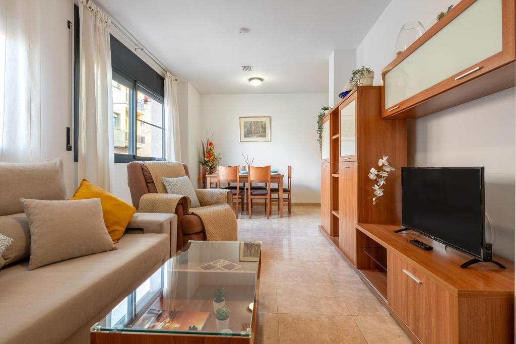 a living room with a couch and a tv at Ca la Mercè in Camarles