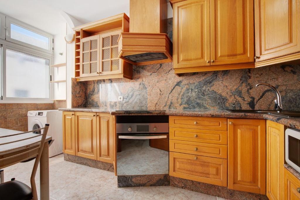 a kitchen with wooden cabinets and a sink at Casa Rosi in Gran Tarajal