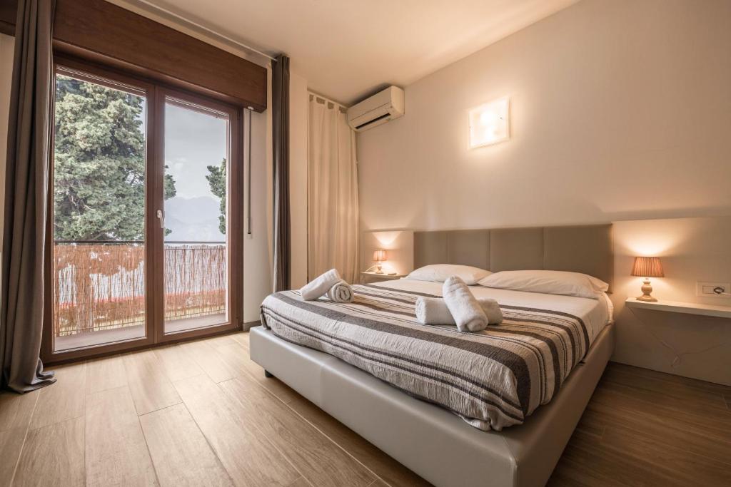 a bedroom with a large bed and a large window at Appartamento Fiocco in Malcesine