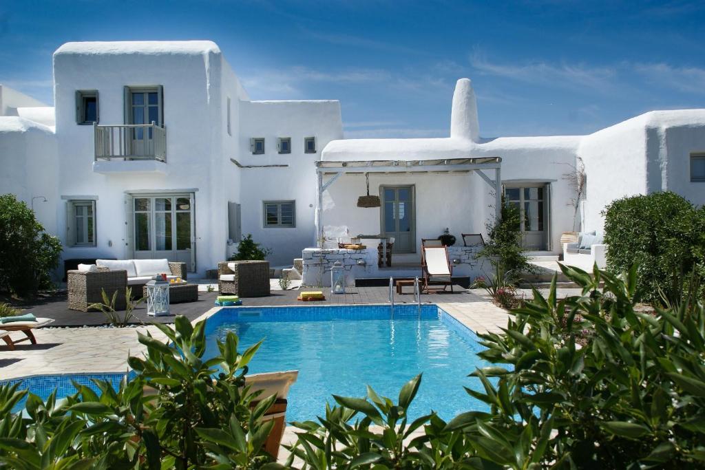 a villa with a swimming pool in front of a house at House with private pool in Naousa