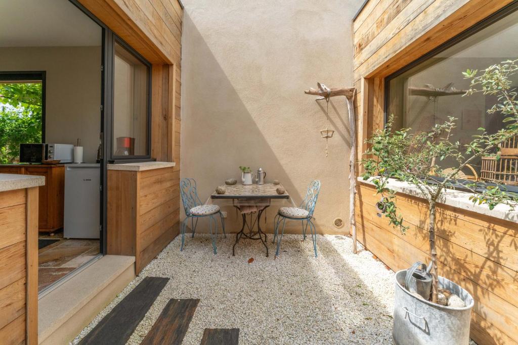 a patio with a table and chairs in a kitchen at Villa La Mireio in Malaucène