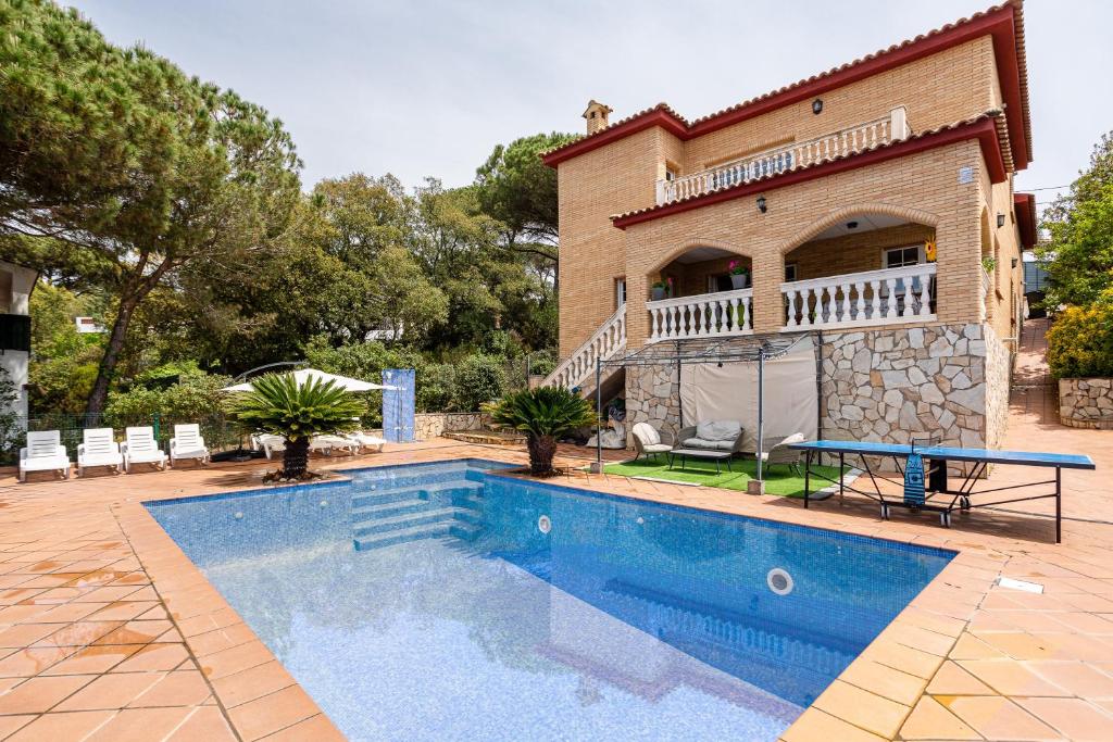 a house with a swimming pool in front of a house at Villa Yulia in Vidreres