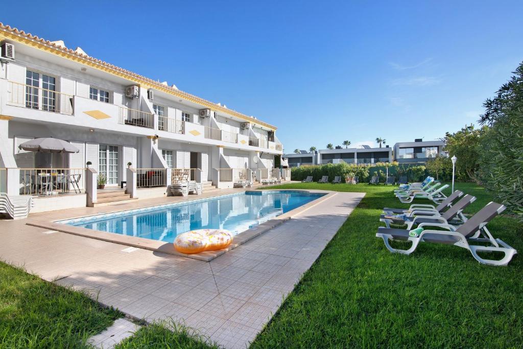 a hotel with a swimming pool and lounge chairs at Villa Martina in Albufeira