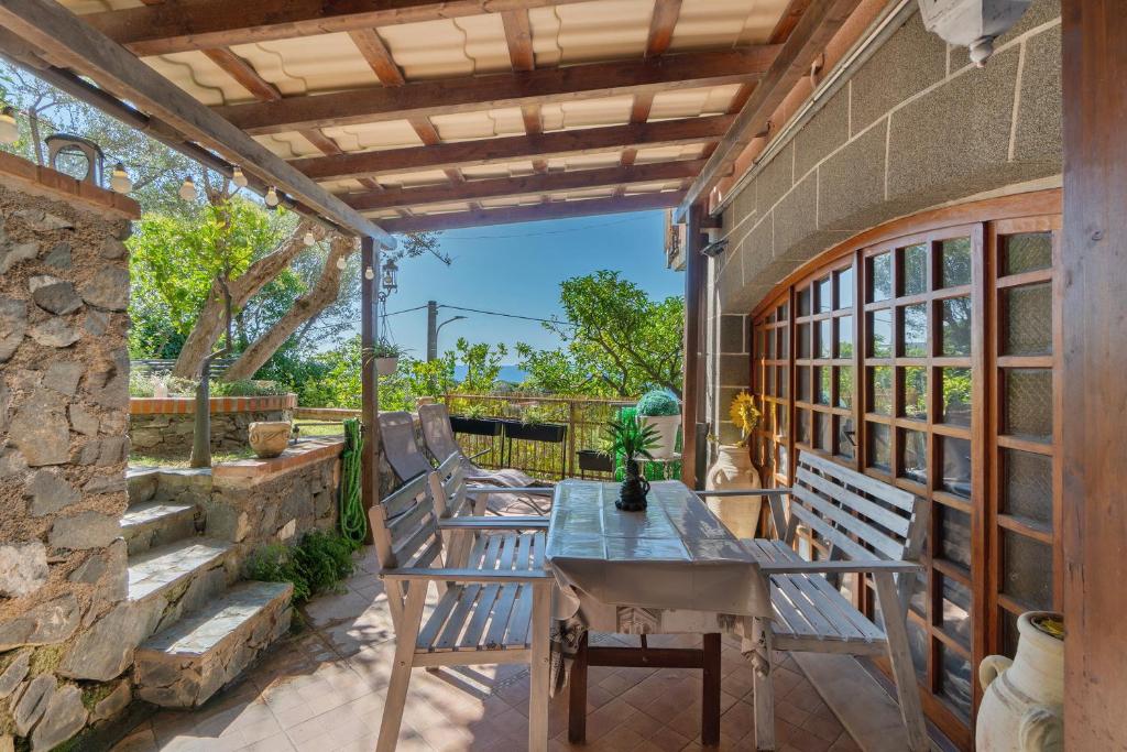 an outdoor patio with a table and benches at Lemon Green in Celle Ligure