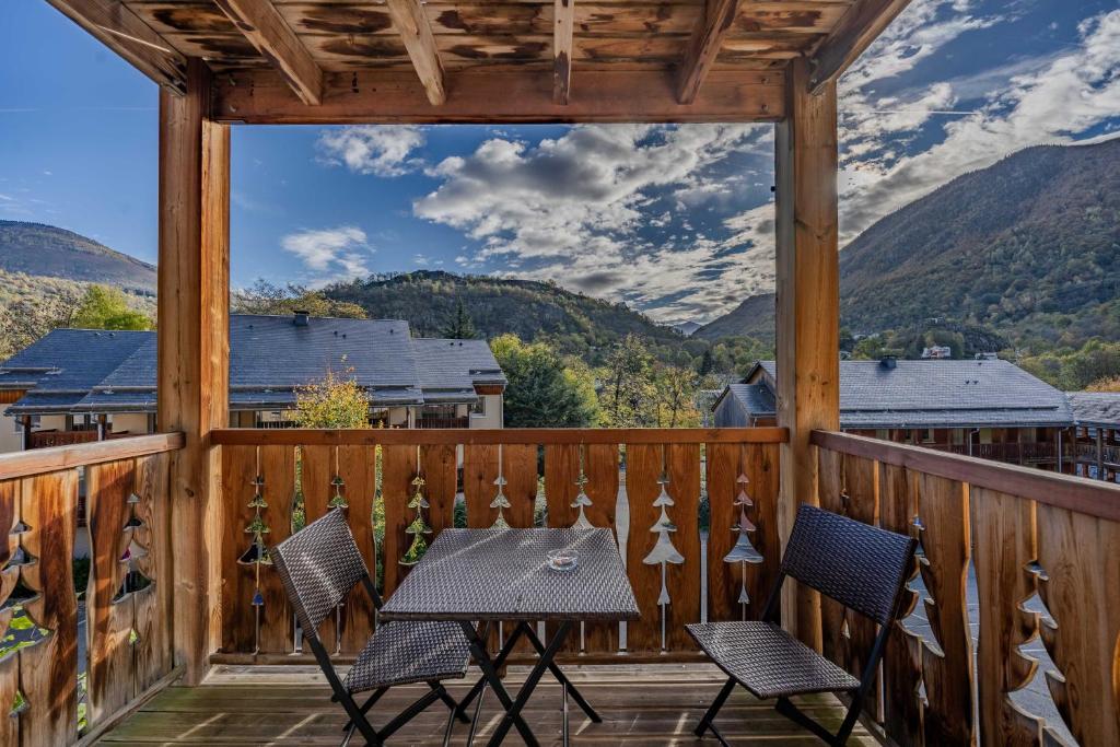 a patio with a table and chairs on a deck at Le calme de Ax in Ax-les-Thermes