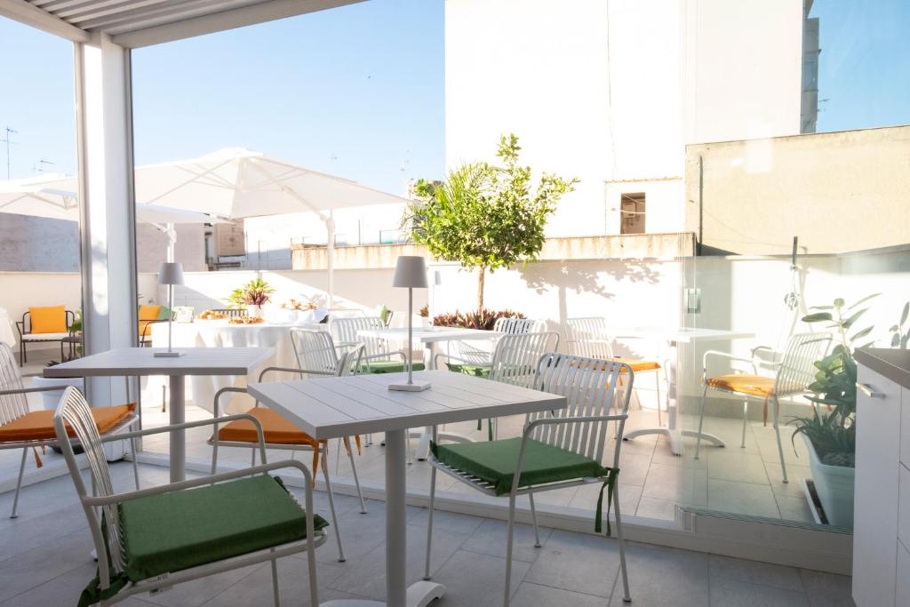 a patio with tables and chairs on a balcony at Fantasia House in Marsala