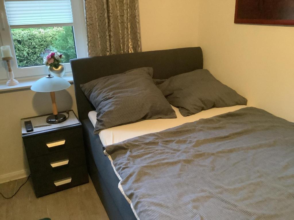 a bedroom with a bed and a nightstand and a window at Bohlen Rhede in Rhede