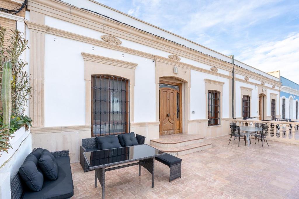 a large white building with a couch and a table at Unique Patacona in Valencia