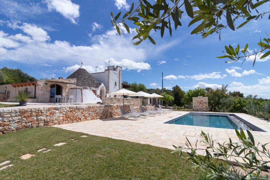an external view of a stone house with a swimming pool at Trulli Tower in Putignano