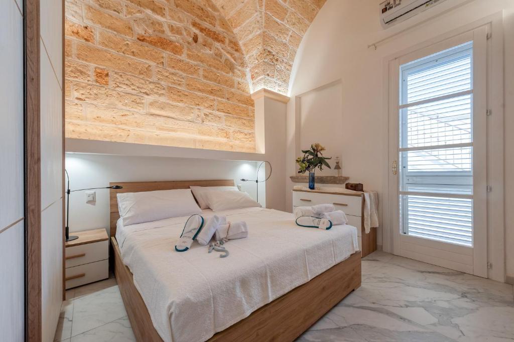 a bedroom with a large bed with a brick wall at Rosy Maison in Squinzano