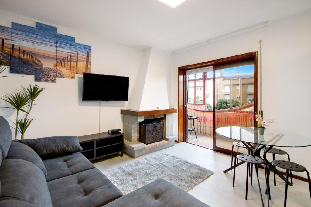 a living room with a couch and a fireplace at Barrinha Beach in Esmoriz