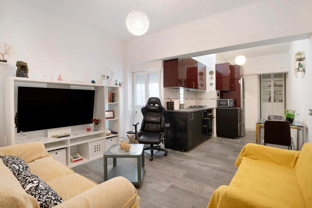 a living room with a couch and a tv and a kitchen at Piso Leon y Castillo in Arrecife