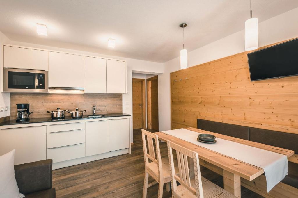 a kitchen and dining room with a table and chairs at Chalet La Flüta Margherita in La Valle