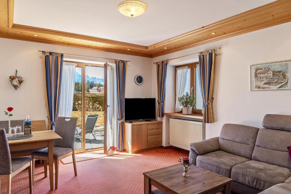 a living room with a couch and a television at Alpenblick Tilly - Fewo Eibsee 1 in Krün