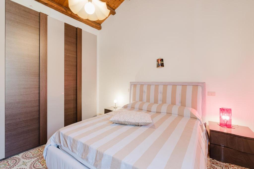 a bedroom with a bed and a dresser with a lamp at Da Giovanni A Custonaci in Custonaci