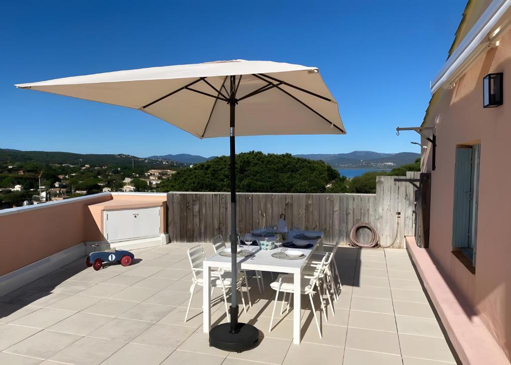 a table and chairs with an umbrella on a balcony at Appartement D'exception in Saint-Tropez