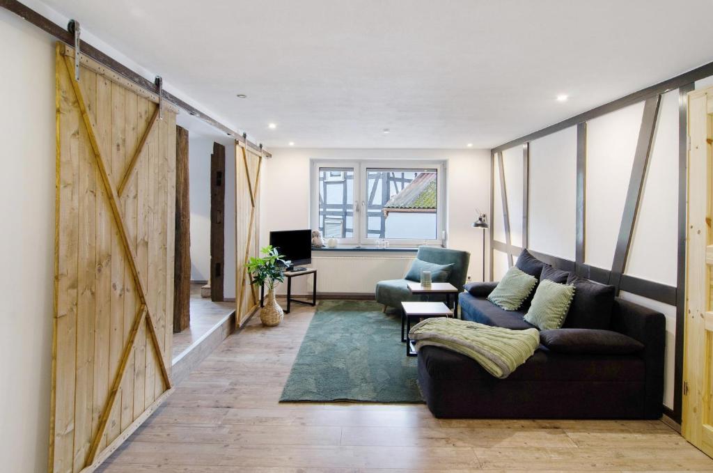 a living room with a couch and a chair at De Lüttje Utkiek in Bühren