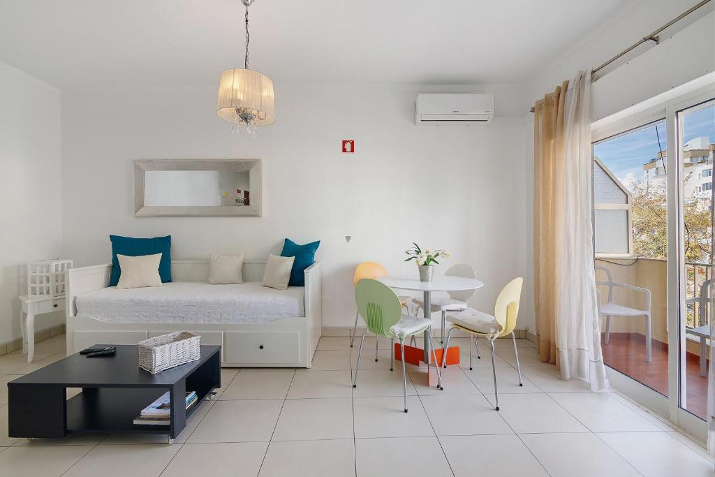 a bedroom with a bed and a table and chairs at Casa De Pardal in Quarteira