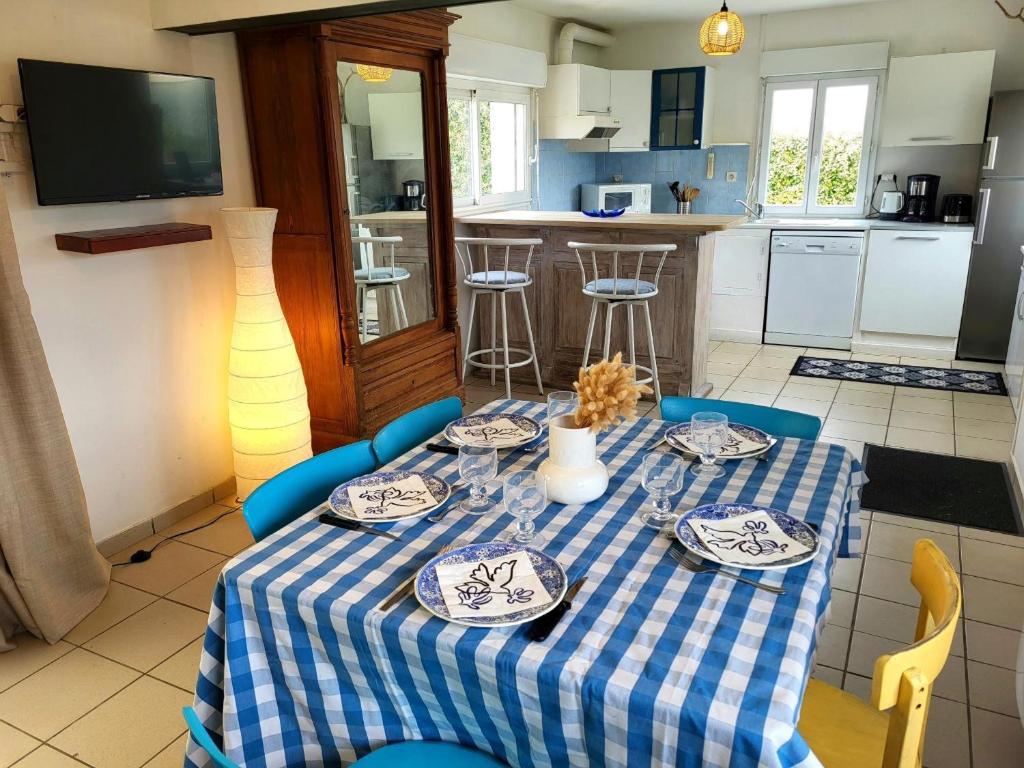 a kitchen with a table with a blue and white table cloth at La Maison Du Rivage in Bretteville-sur-Ay