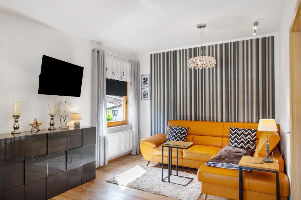 a living room with a yellow couch and a tv at Ferienwohnung Gabi in Malchow