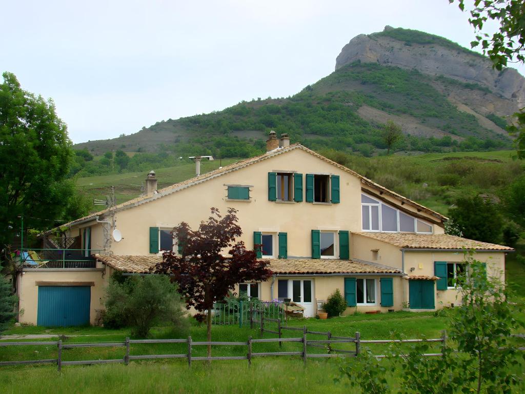 a house with a mountain in the background at Gîte Paysan La Grange in Montrond