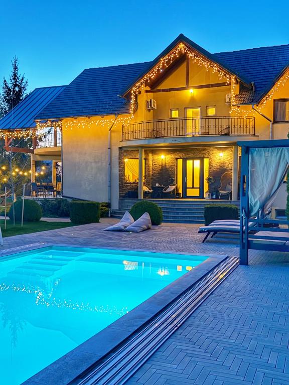 a house with a swimming pool in front of a house at Orchard Villa in Braşov