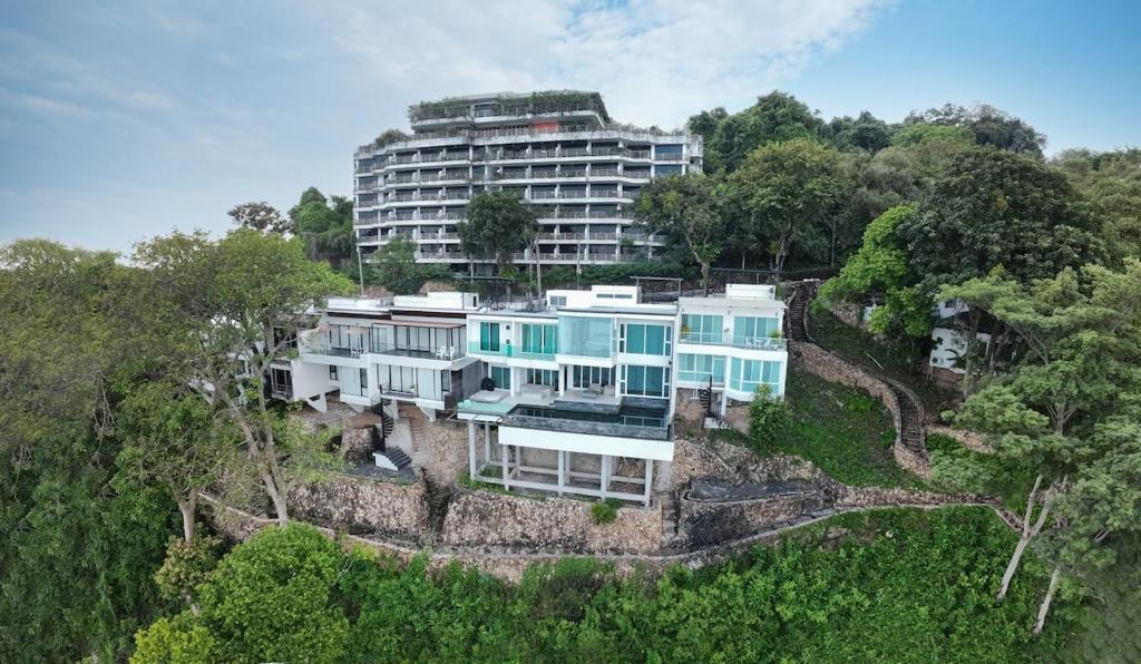 a house on a hill with a large building at P8 Cliff House Stunning Seaview in Ban Ko Kok