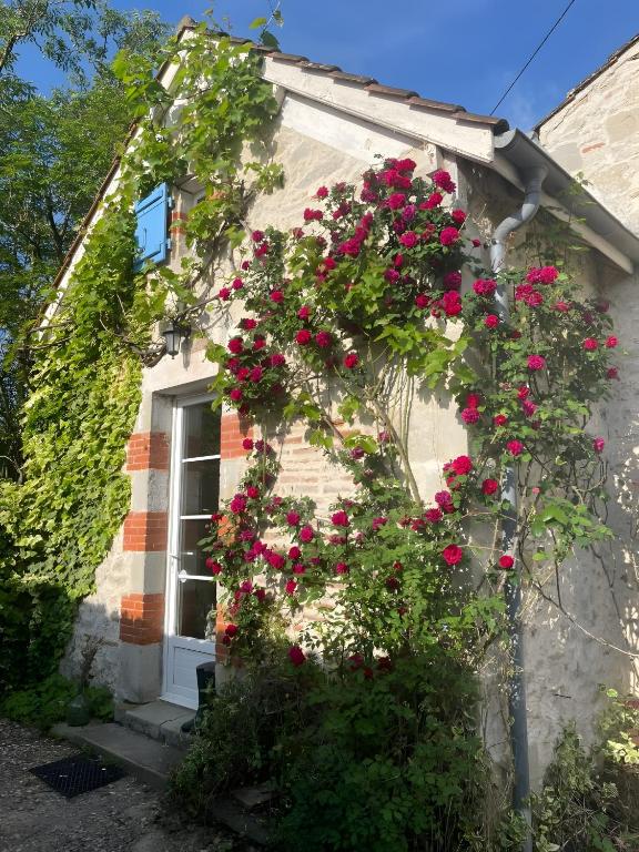 a building with pink flowers on the side of it at Le Gite Amical des Chiens in Penne-dʼAgenais