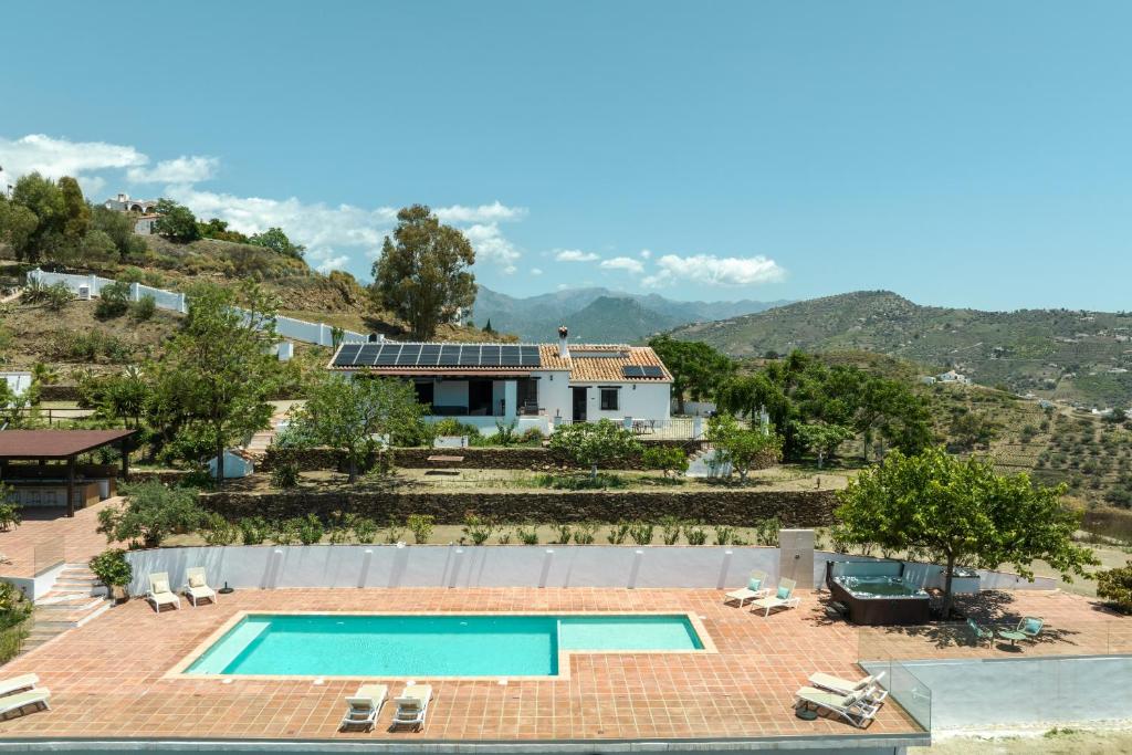 a villa with a swimming pool and a house at Finca Mojito in Cómpeta