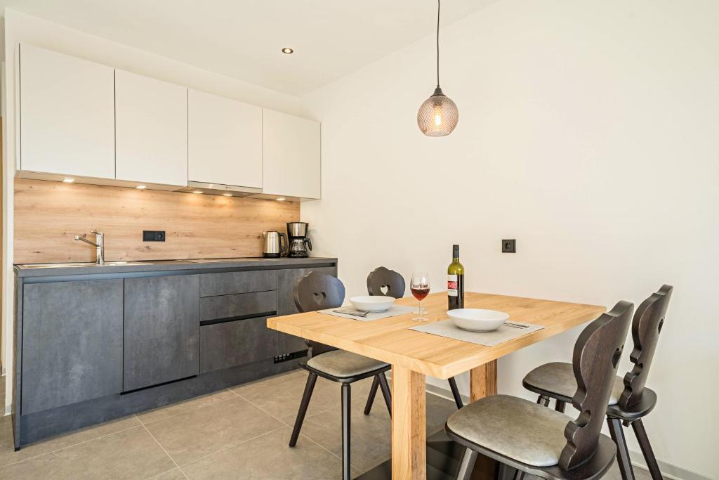 a kitchen with a wooden table and chairs at Sunnig Apartment Sonnenschein in Vollan