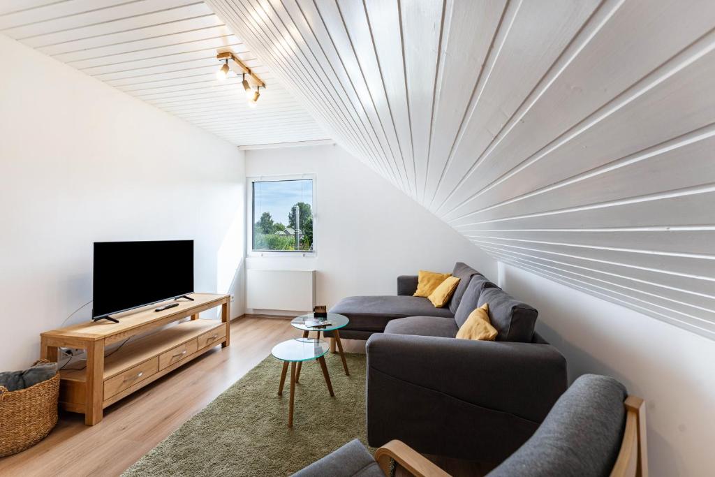 a living room with a couch and a tv at Zwischen den Wellen in Oldenburg in Holstein