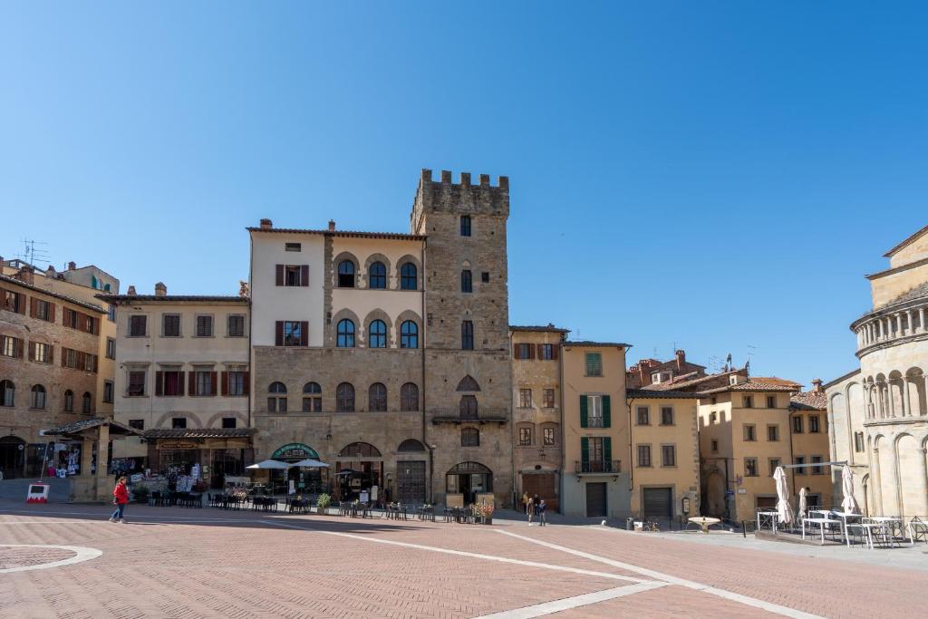 a group of buildings in a square with a tower at Palazzo Cofani in Arezzo