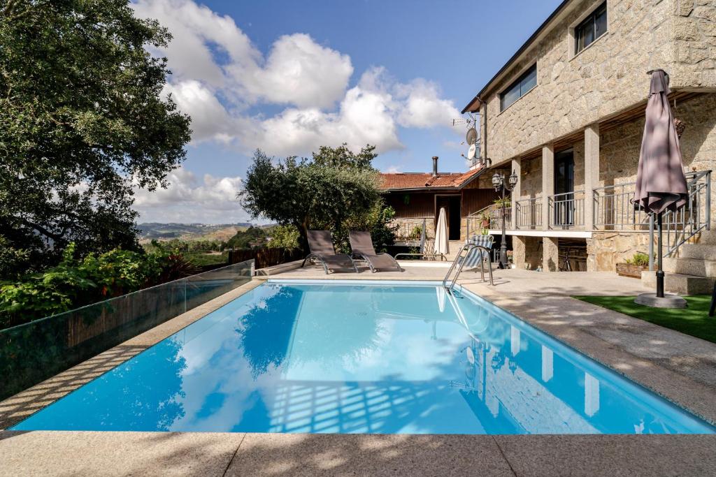 a swimming pool in front of a house at Casa Real De Cima in Fervença
