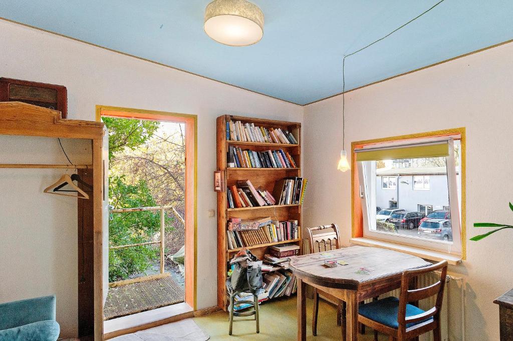 a dining room with a table and a book shelf at Fuchsbau In Der Ktv in Rostock