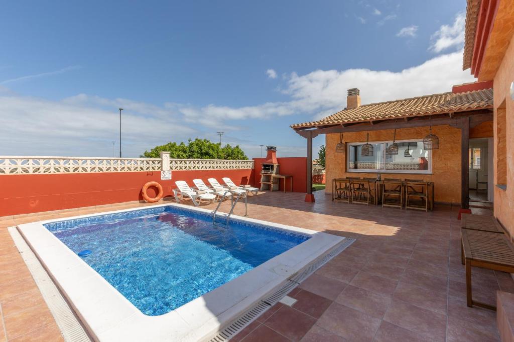 a swimming pool on a patio next to a house at Villa Atlantic Ocean Private Pool in Corralejo