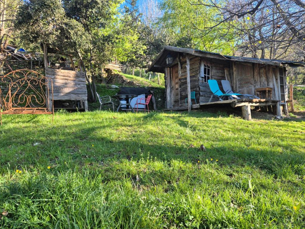 a log cabin with a bench and a table at Cabane en Cévennes in Saint-Germain-de-Calberte
