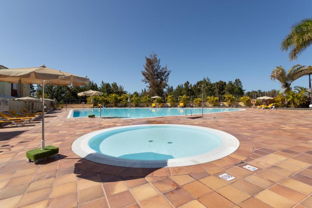 a large swimming pool with a large circle in the middle at Sunset Villa Meloneras in Maspalomas